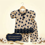 A two-piece baby outfit set consisting of a short-sleeve top and matching pants, displayed on a wooden hanger against a warm cream background. The set features a beige base with a navy blue floral pattern, a navy blue lace-trimmed collar and hem, and decorative embroidered details.