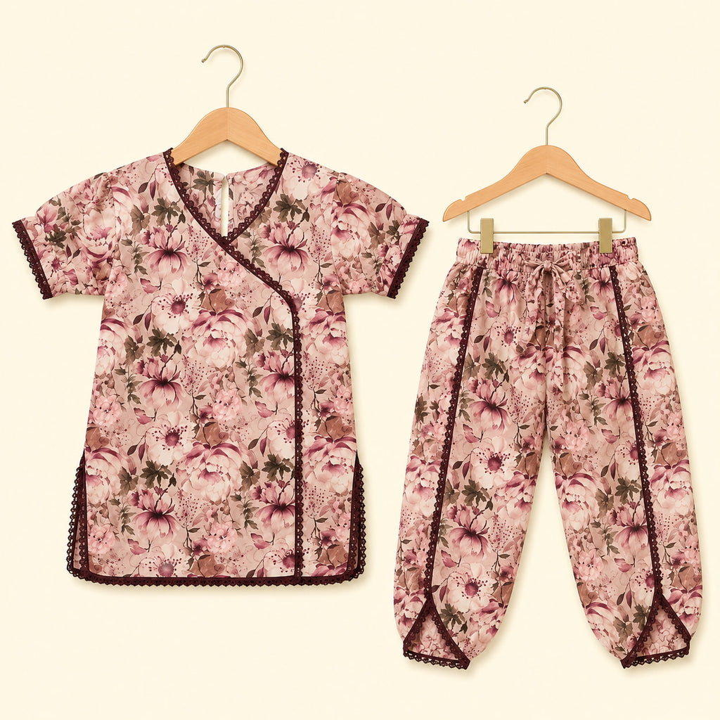 A two-piece children's outfit set consisting of a short-sleeve wrap-style top and matching pants, both featuring a pink and brown floral print with dark brown trim, displayed on wooden hangers against a light cream background.